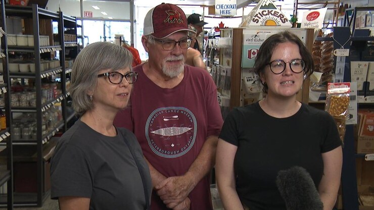 Two women and a man speak to a reporter.