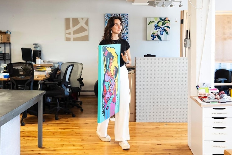 A woman holding a painting.