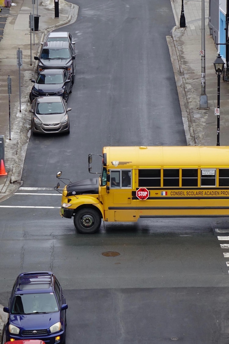 Un autobus scolaire traverse l'intersection de deux rues étroites.