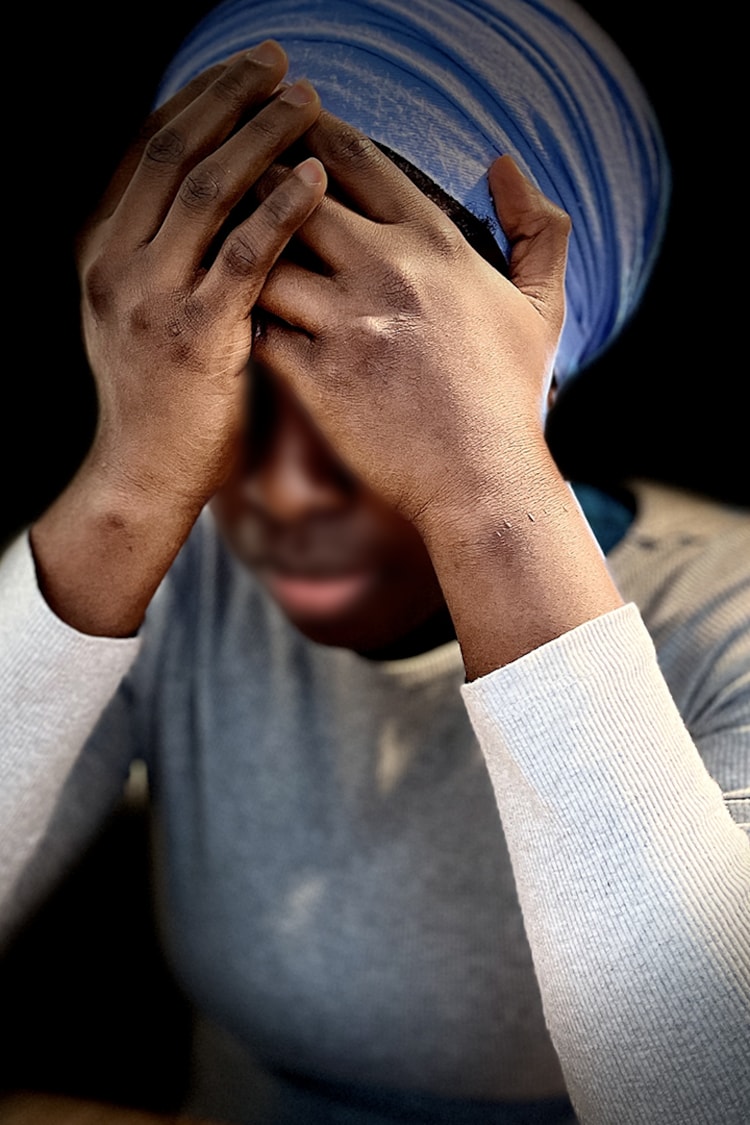 Une femme prend sa tête entre ses mains.