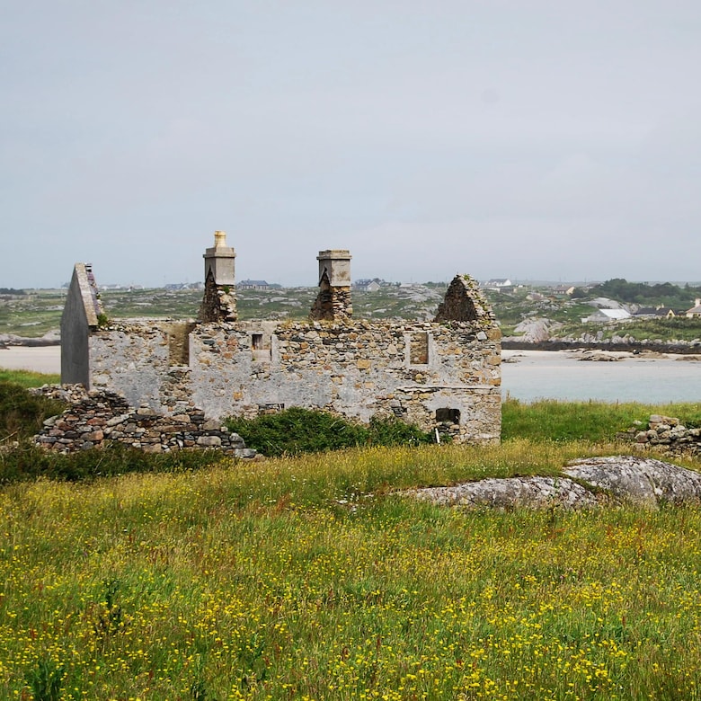 Vieux bâtiment irlandais de pierre en ruine près d'un plan d'eau.