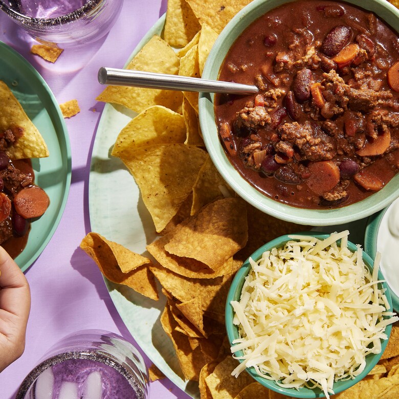 Du chili rapide servi avec du fromage râpé, de la crème sure et des chips de tortillas.