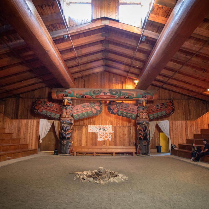 L'intérieur de la Big House, avec deux totems traditionnels autochtones et un foyer au centre, à Klemtu, en Colombie-Britannique, en octobre 2023.