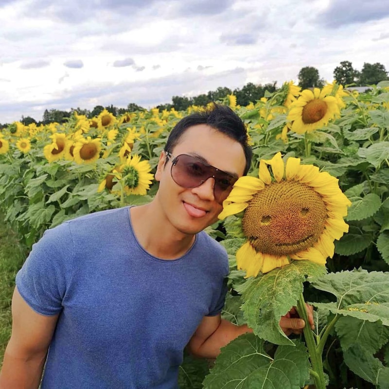 Un instagrameur abîme un tournesol pour lui faire un visage dans un champs d'une ferme de Bogle Seeds en Ontario.