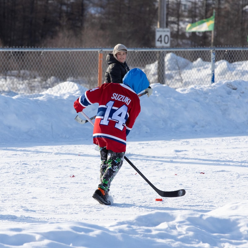Un jeune Inuk joue au hockey.