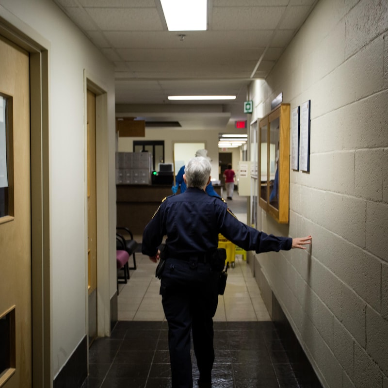 Une gardienne de prison marche dans un corridor