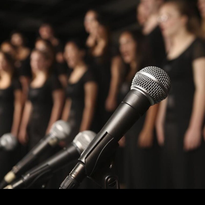 Image floue d'une chorale avec au premier plan des micros.