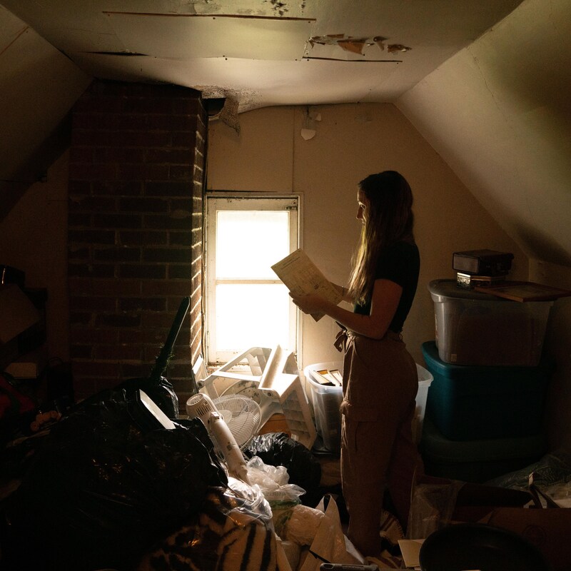 Éliana Lapierre se tient droite et lit un papier qu'elle a trouvé dans une boîte du grenier.