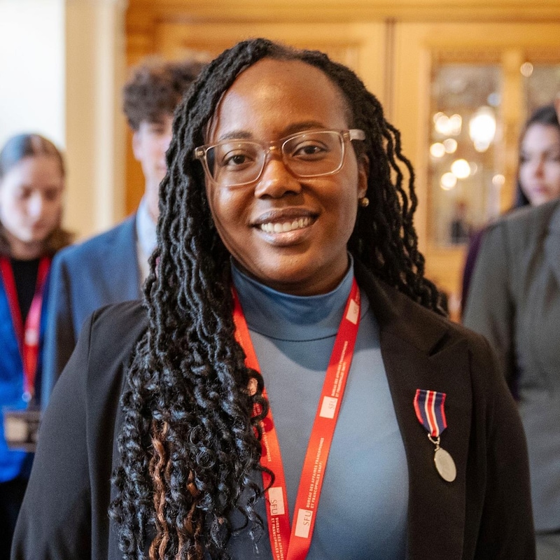 Blanche Monabeka au premier plan, avec derrière des personnes, dans un couloir du parlement jeunesse de Victoria, en Colombie-Britannique, en janvier 2026.