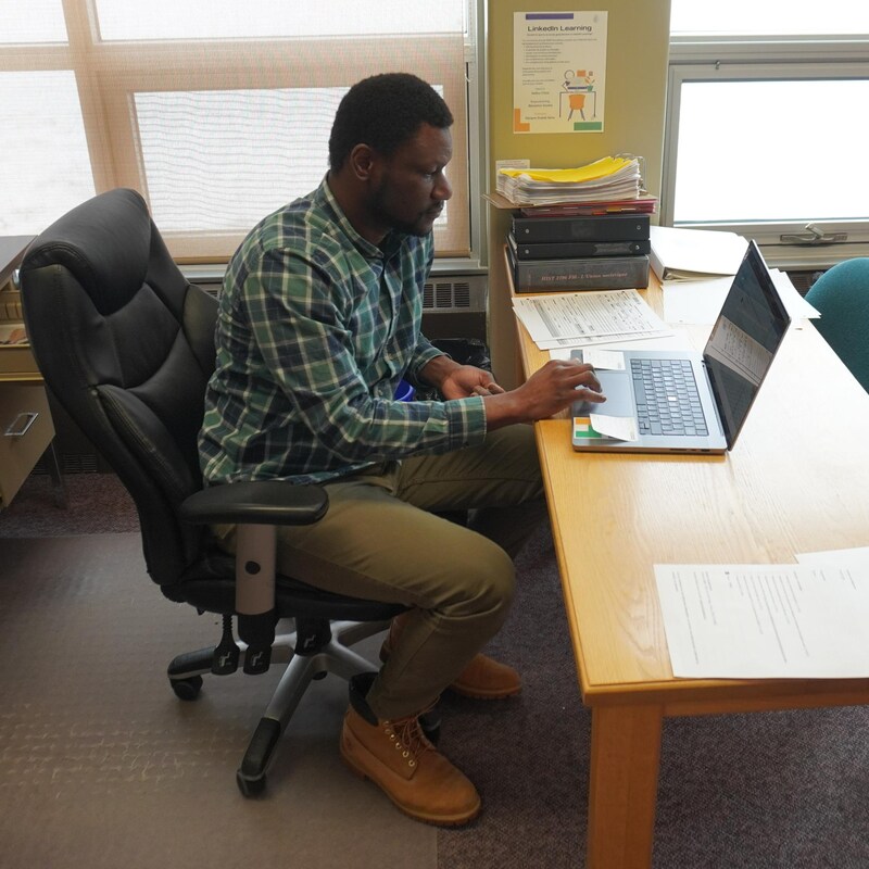 Papa Ibrahima Coulibaly travaille à son bureau.