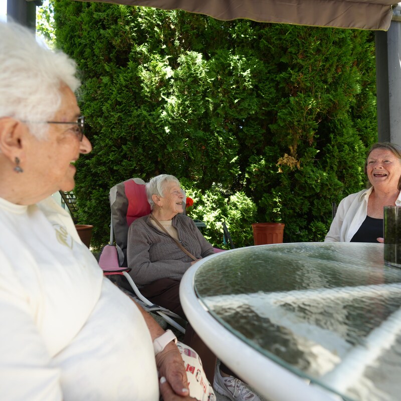 Lucille Proulx dehors autour d'une table avec deux amies, à Victoria, en Colombie-Britannique, en juin 2023.