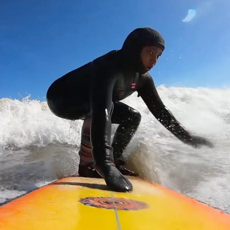 Juniper qui surf sur une vague.