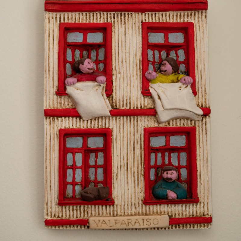 La petite sculpture montre des gens qui discutent aux fenêtres en étendant des draps.