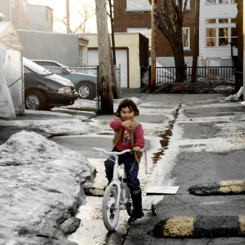 Daphné-Anne Olepika, fillette, fait de la bicyclette dans une ruelle enneigée.