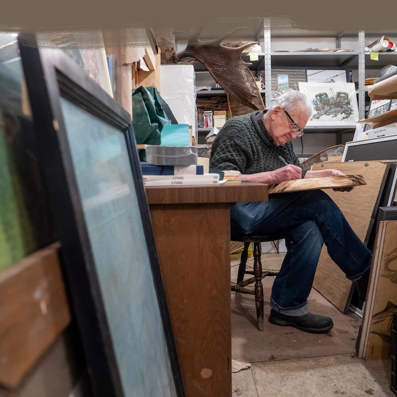Jim Robb qui dessine assis dans son atelier 