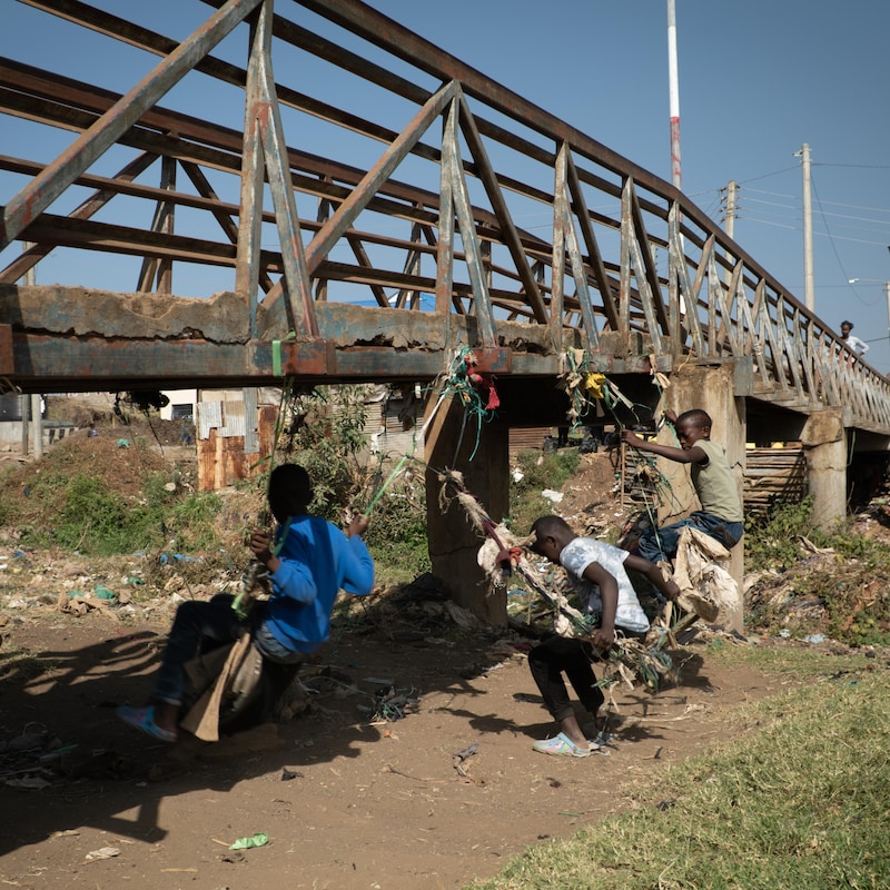 Des enfants jouent sous un pont.