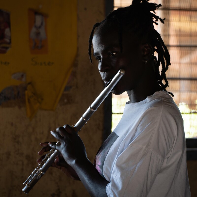 Une adolescente joue de la flûte traversière.