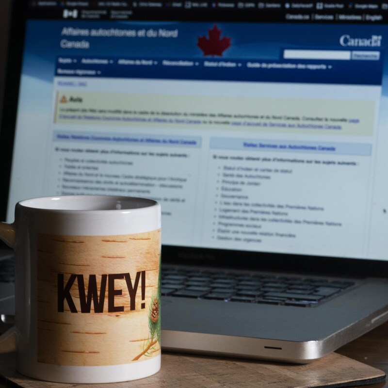 Une tasse avant un écran en arrière plan