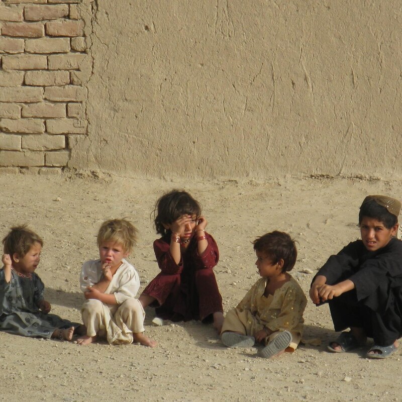 Cinq enfants assis sur le sol.