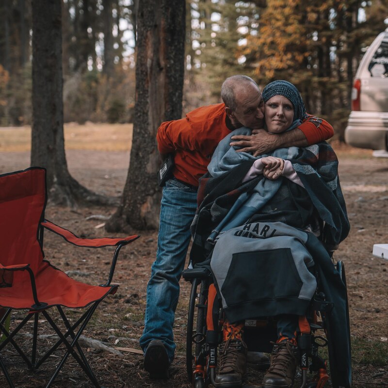 Denis tient Caroline dans ses bras, dans la forêt, en octobre 2022, dans les Rocheuses, en Alberta.
