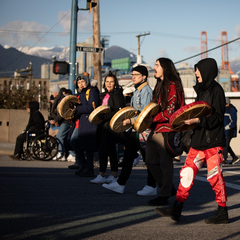 Des manifestants marchent avec des tambours traditionnels.
