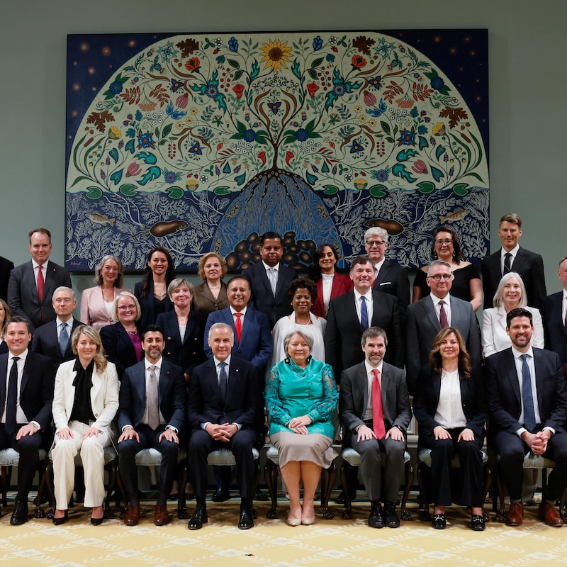Portrait de famille montrant Mark Carney et Mary Simon assis au centre, entourés par les 28 ministres et secrétaires d'État à Rideau Hall.