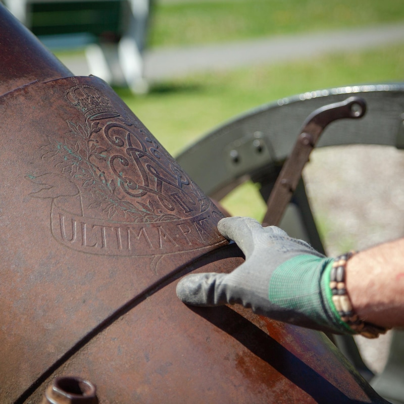 La main de Jean Guy montre les détails d'un logo gravé à-même le canon