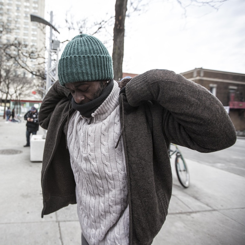 Un homme essaie la nouvelle veste qu'il a déniché dans les sacs de dons.