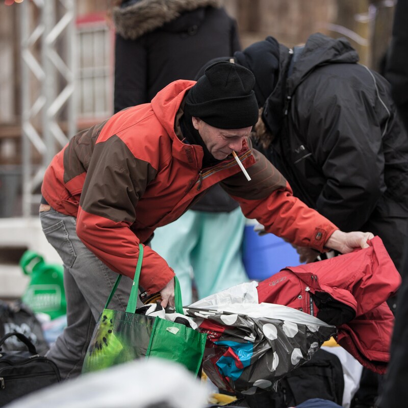 Des personnes cherchent dans les sacs de dons.