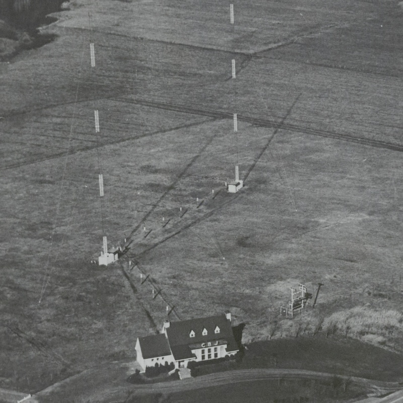 Vue aérienne d'un émetteur dans un champ à côté d'une maison.