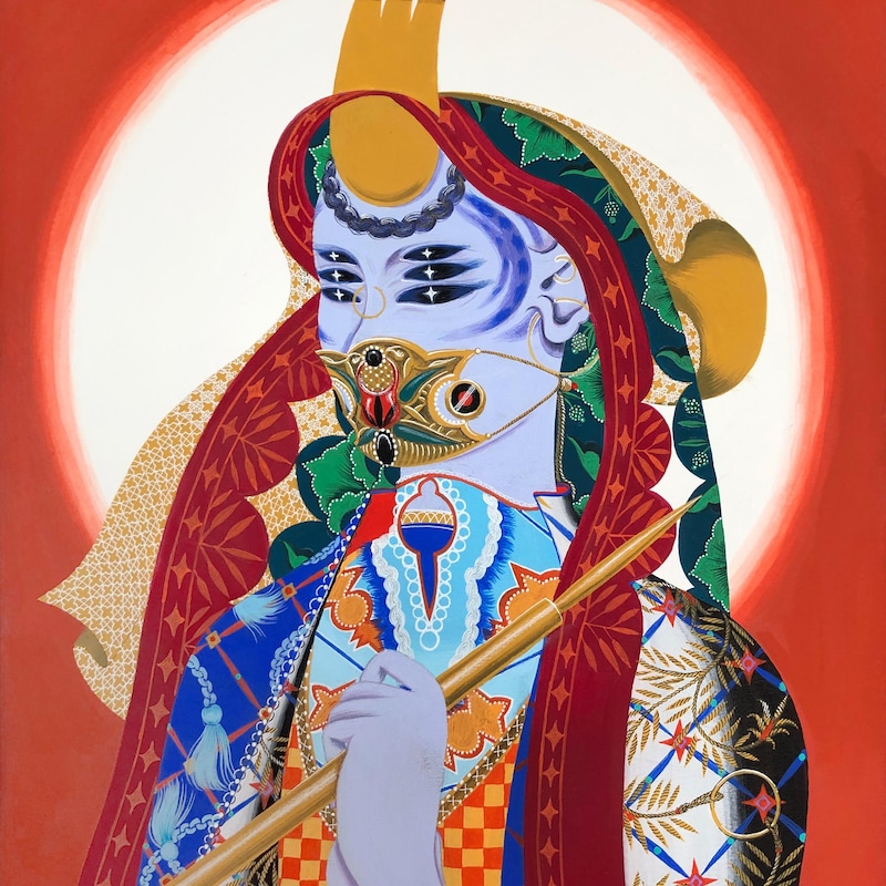 Une figure tirée de la mythologie sri-lankaise, avec plusieurs yeux, se tient devant un fond orange.