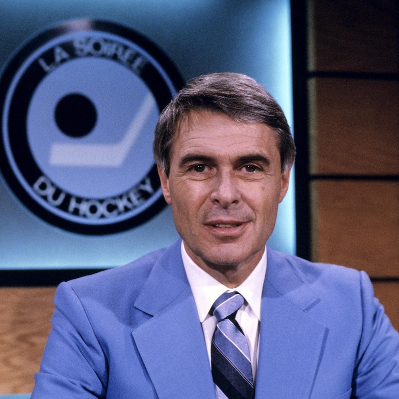 Dans un studio de télévision, Richard Garneau est assis. Derrière lui, sur le mur, on voit le logo de l'émission.