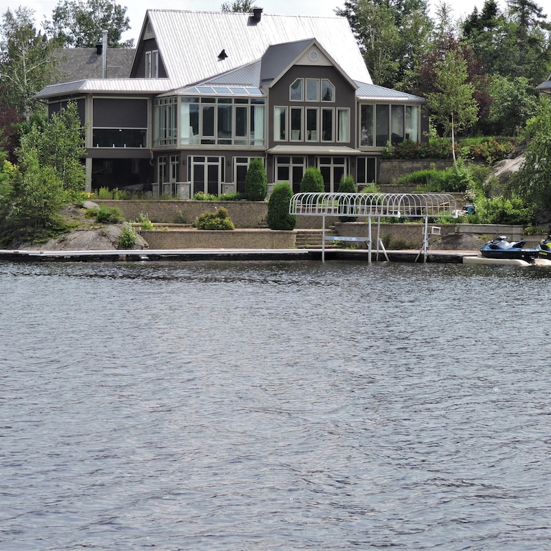 Maison sur le bord du lac avec deux motomarines.