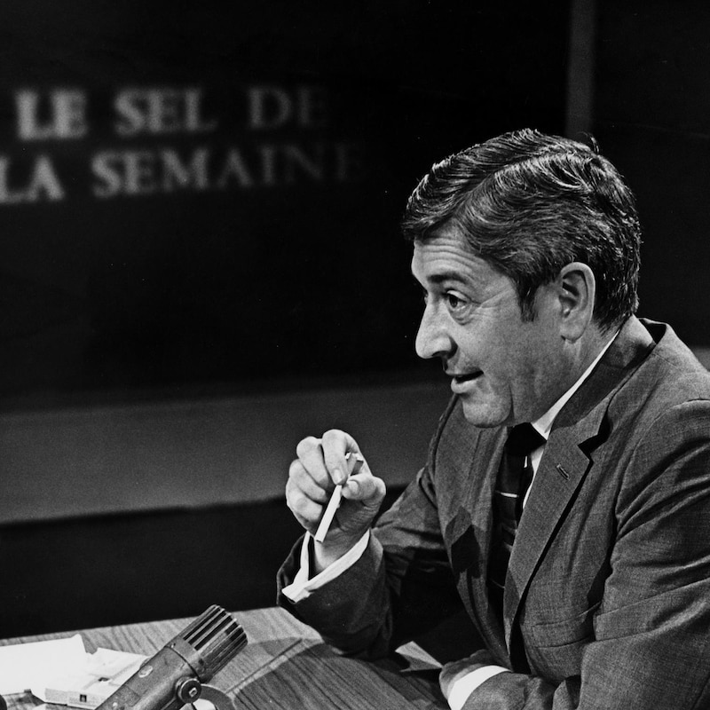 En studio, à sa tribune de l'émission, l'animateur Fernand Seguin derrière son micro.