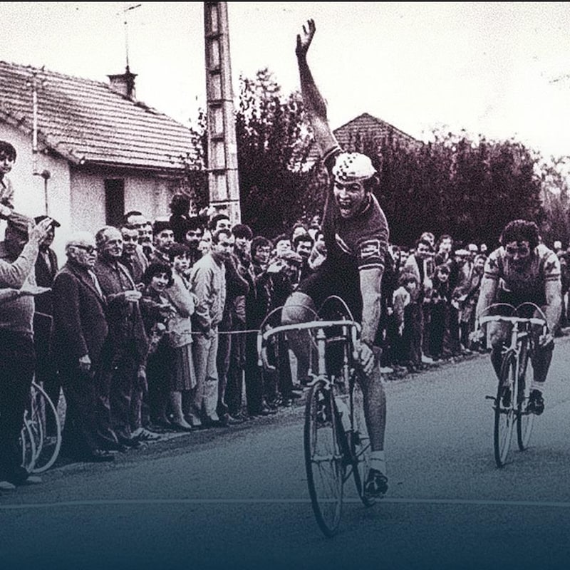 Le cycliste Dany Deslongchamps lève un bras en croisant la ligne d'arrivée d'une course.
