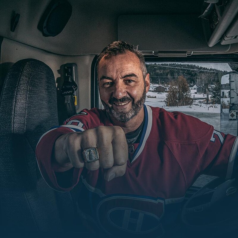 Assis dans la cabine de son camion, Jesse Bélanger sourit en montrant sa bague de la Coupe Stanley.
