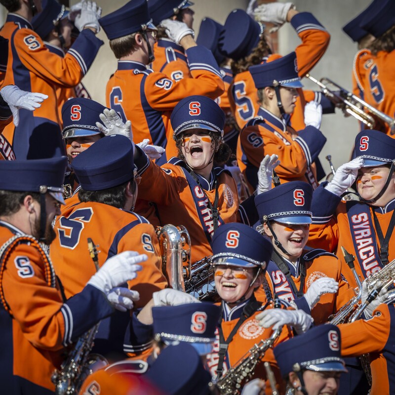 Des musiciens d'une fanfare vêtus de bleu et d'orange