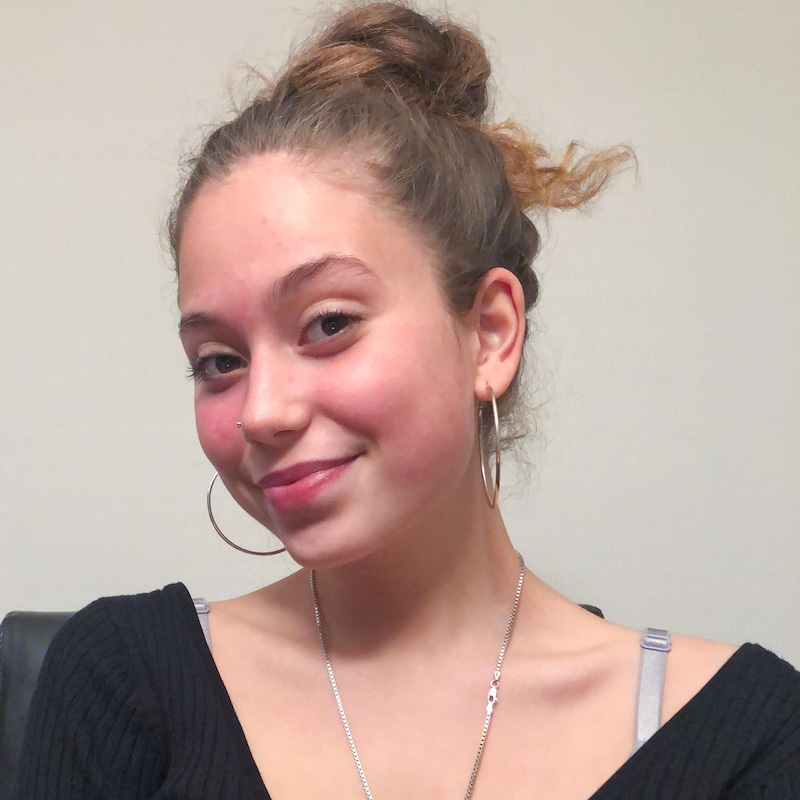 L'adolescente pose en souriant.