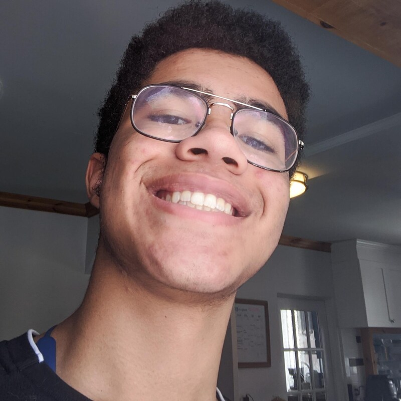 Le jeune homme à lunettes sourit en prenant un egoportrait très rapproché.