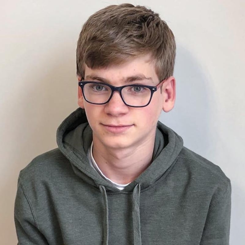 L'adolescent pose en souriant.