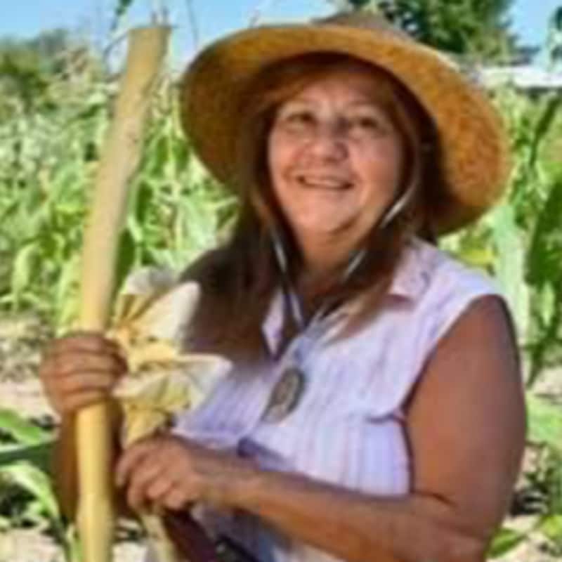 Terrylynn Brant pose avec des légumes cultivés sur sa terre.