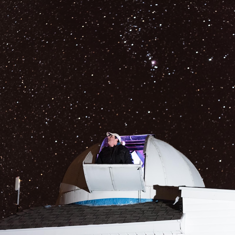 Tim Doucette regarde le ciel étoilé à partir du dôme de son observatoire.