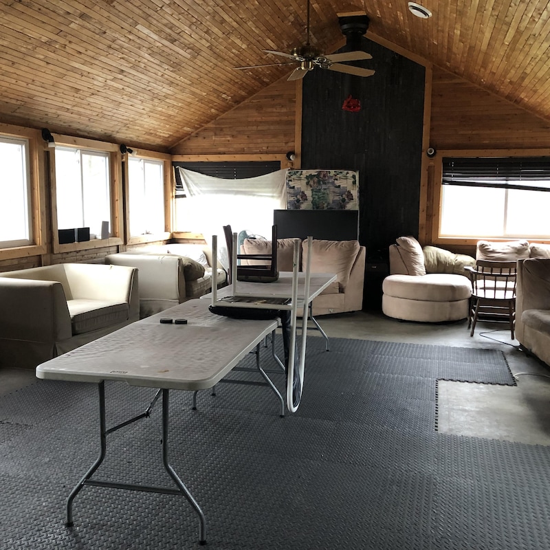 Un salon encombré de divans, d'une table et de chaises.