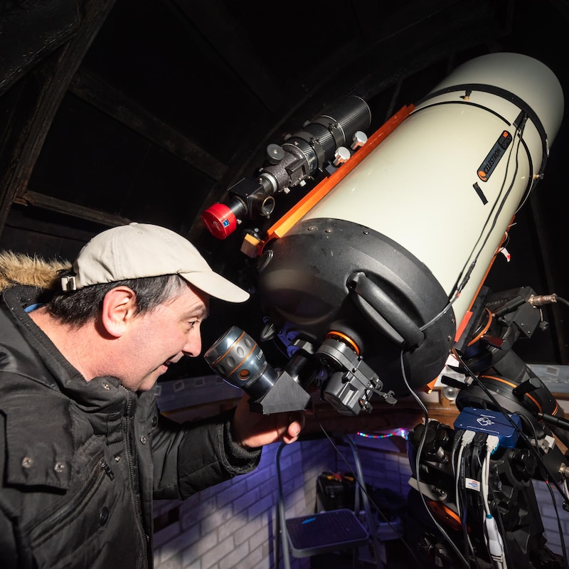 Tim Doucette regarde dans un gros télescope.