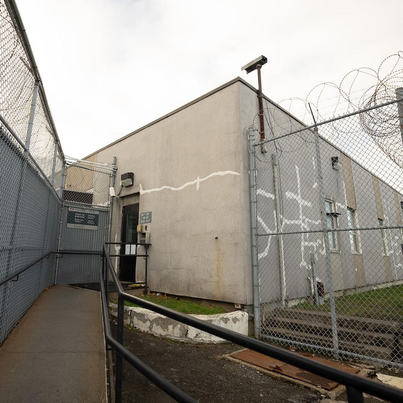 Un centre de détention entouré de grandes clôtures recouvertes de barbelés.