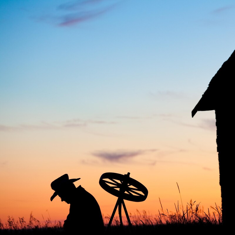 Silhouette d'un fermier au coucher du soleil.