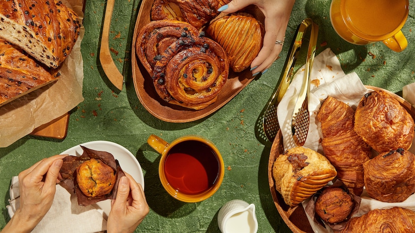 Plusieurs viennoiseries dans des assiettes sur une table.