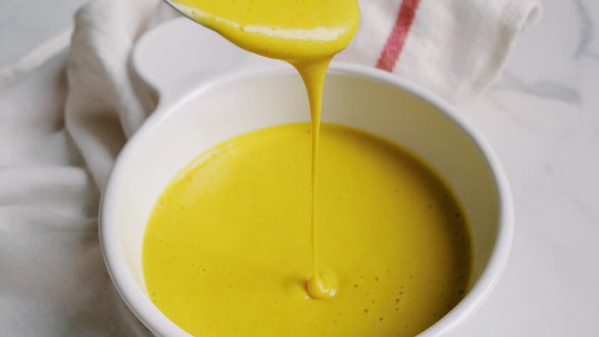 De la sauce végétalienne style jaune d'œuf versée dans un bol.