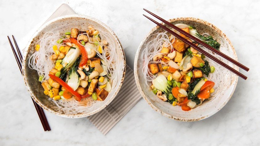 2 bols contenants des nouilles de riz, des légumes et du tofu.  