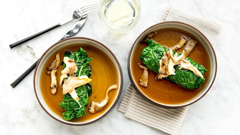 2 bols contenants une feuille de bette à carde roulée, des champignons pleurotes sur une bouillon.